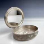 A Steling silver ladies powder compact, of oval section, the hinged lid with engraved monogram and