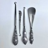 Four dressing table implements with silver filled handles, one a button hook with 'Punch' handle.