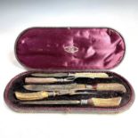 A Victorian cased meat carving set with antler handles and with silver collars and caps, by Joseph