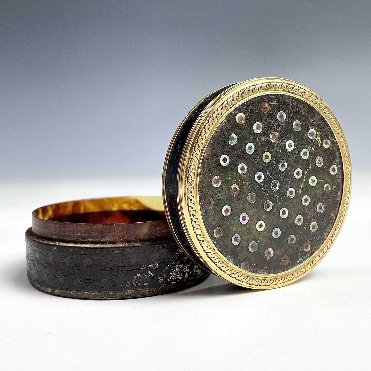 A 18th century French gold mounted mother of pearl dot inlaid circular section snuff box, diameter