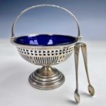 A George V silver sugar basket with chased swing handle and blue glass liner by George Unite,