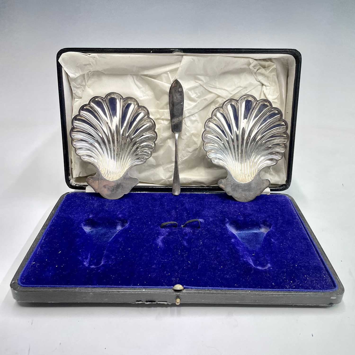 A George V cased pair of scallop shell butter dishes by Elkington & Co, together with one butter