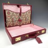 A Harrods red leather briefcase with tapesty cover and pink shot silk interior, width 43cm.Condition