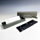 A Gucci unisex black leather wrist wallet, within original box.