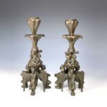 A pair of late 19th century bronze ecclesiastical gothic candlesticks, the bases modelled with three