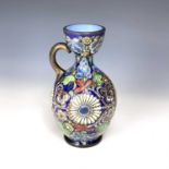 A 19th century blue glass enamelled bottle vase decorated with flowers and foliage, height 17cm.