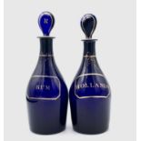 Two Georgian Bristol blue decanters with stoppers, each inscribed in gilt within a faux label, 'Rum'