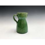 A circa 1900 tin glazed green folk art, face mask jug, height 20cm.