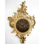 An 18th century carved gilt wood rococo wall clock, fitted a ciricular brass face now with a later