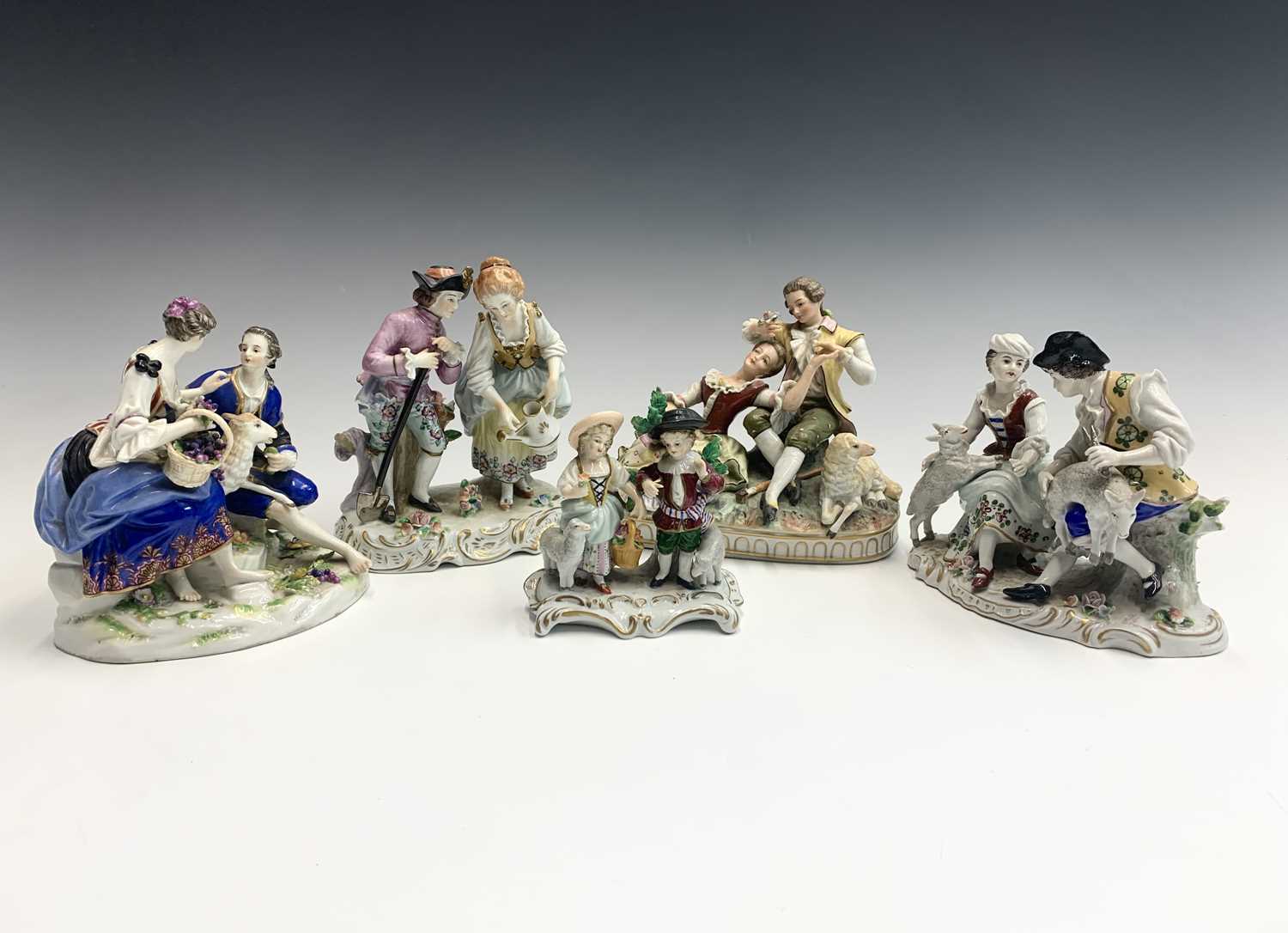 A Sitzendorf group of sheep shearers, 20th century, height 14cm, together with a similar group of