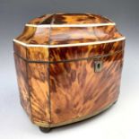 An early Victorian bow front tortoiseshell tea caddy, with two internal lidded compartments, on ball