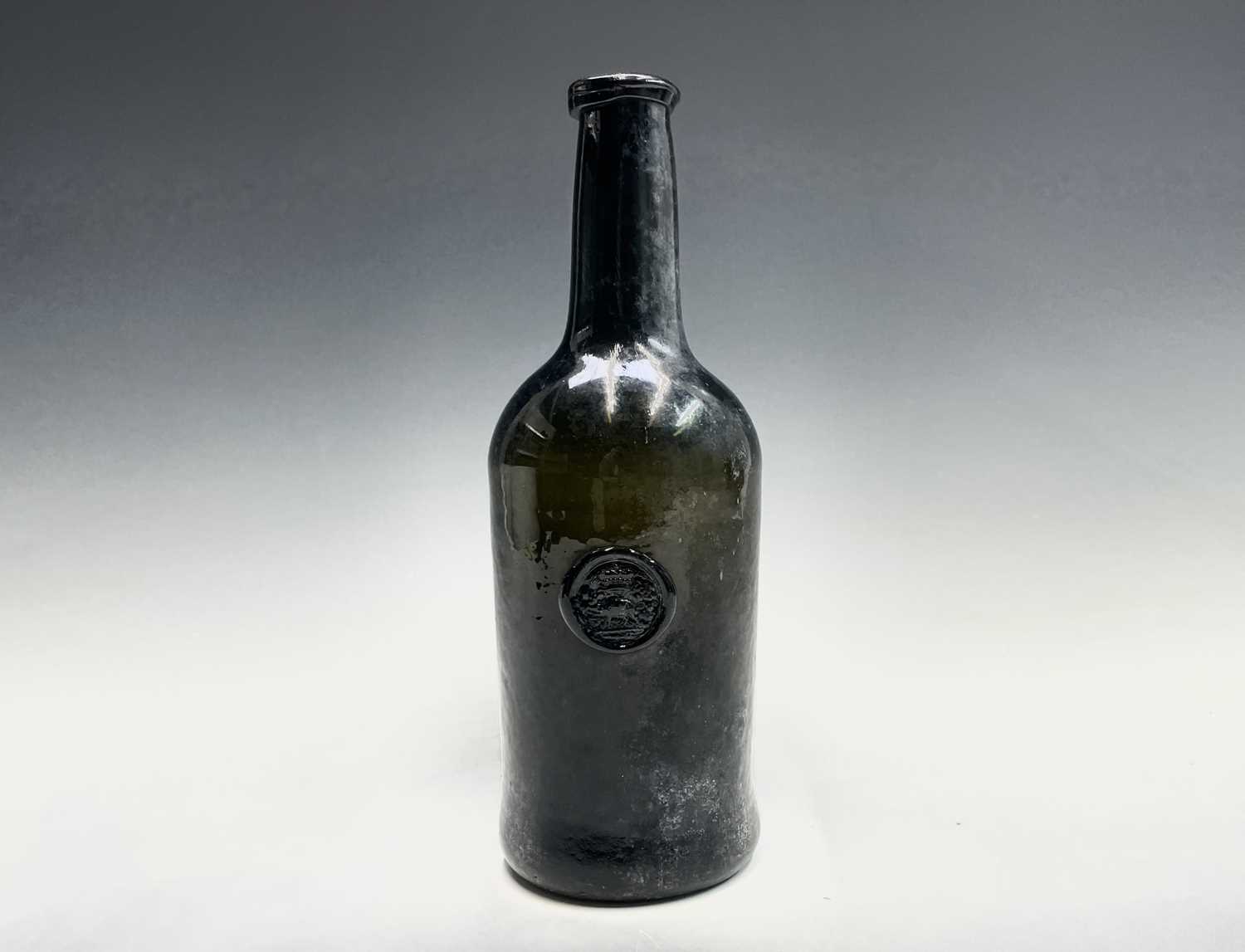 A mid 18th century sealed wine bottle, thick olive green, with kick-in base, the seal with a crown