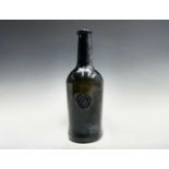 A mid 18th century sealed wine bottle, thick olive green, with kick-in base, the seal with a crown