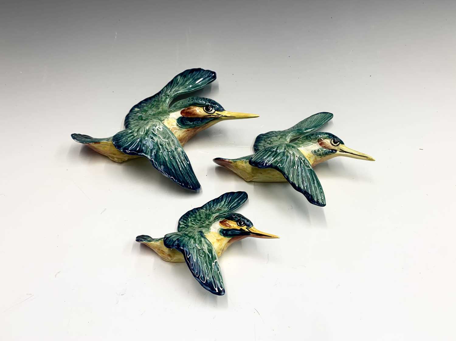 A set of three Beswick pottery graduated wall plaques modelled as kingfishers, printed and impressed