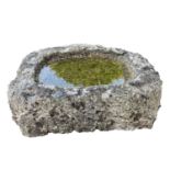 A shallow granite trough of a rough hewn appearance, length. 78.5cm max depth 65cm