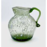 A Nailsea type glass jug, circa 1800, pale green with opaque white mottling, height 15cm.Provenance: