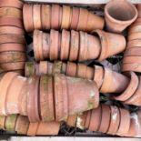 Three crates of terracotta plant pots of various sizes.