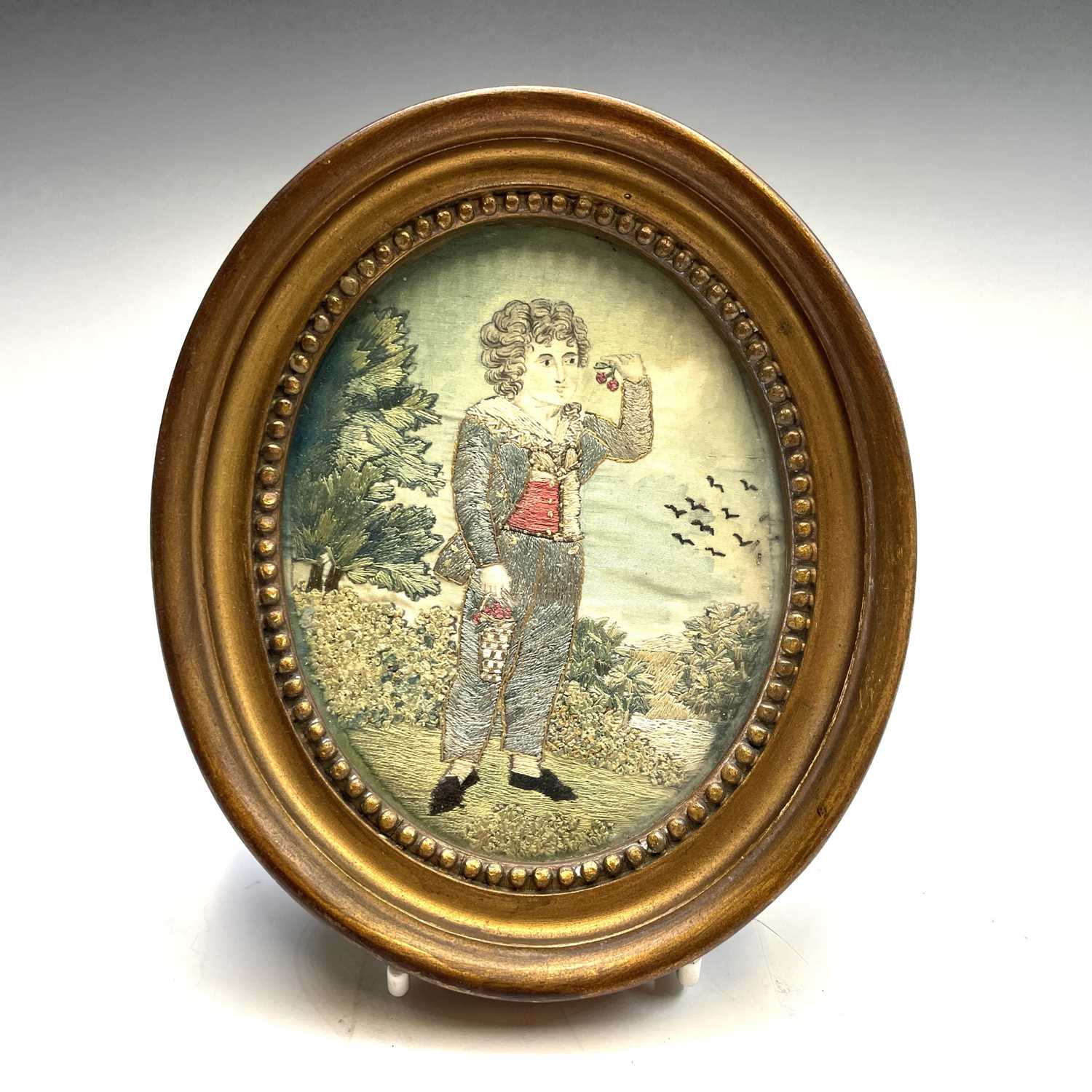 A pair of Regency small oval silk work pictures, with a boy picking fruit and a girl with a doll, - Image 3 of 17