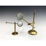 A 19th century brass pillar extending desk magnifying glass together with another larger 20th