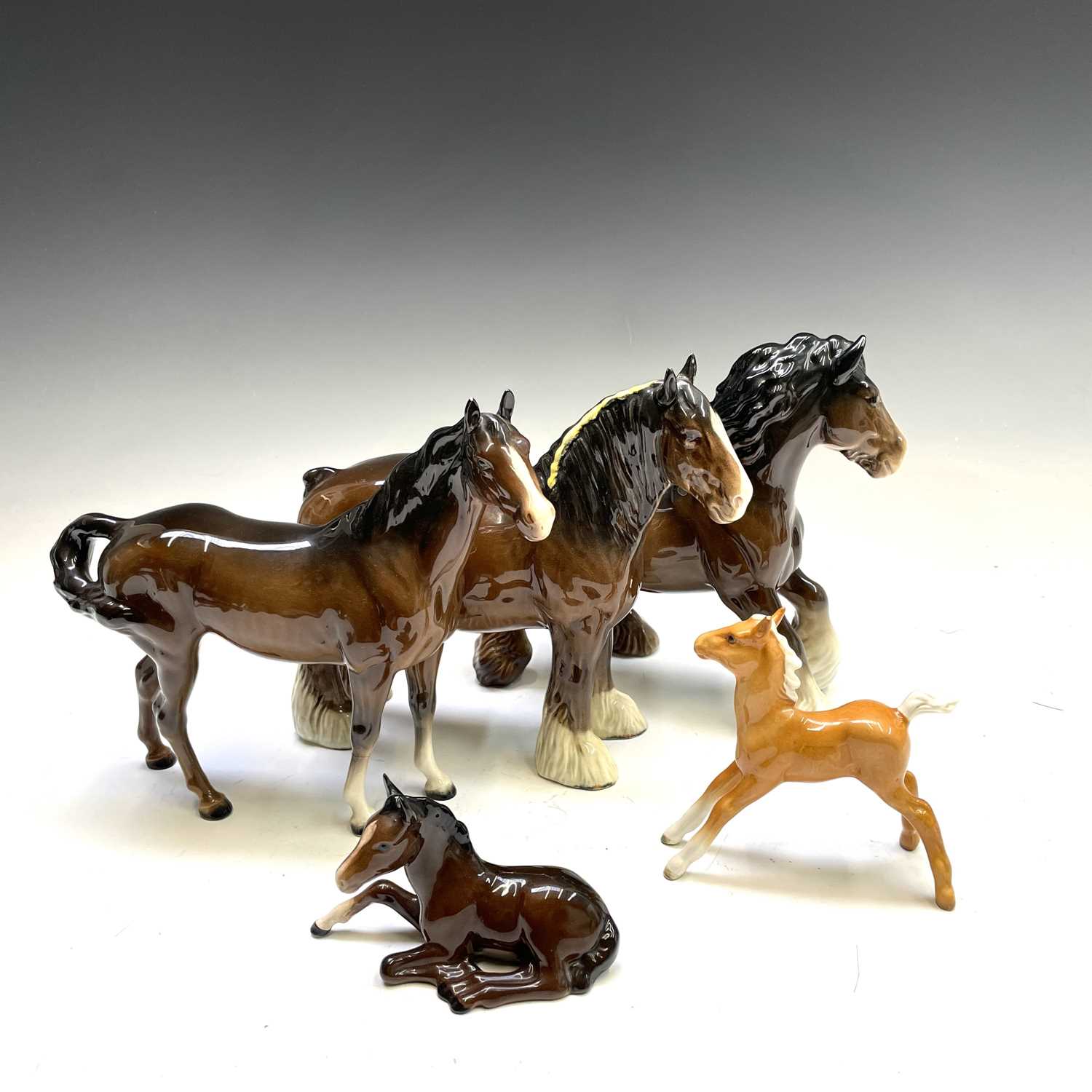 A Beswick pottery cantering shire horse, together with a shire horse with a yellow braid, and a