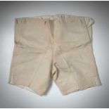 A pair of child's silk breeches with a name label stitched to the interior.