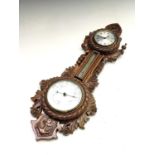 A late Victorian walnut clock/barometer, with flower, foliate and anchor carved decoration, with