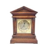 A German walnut architectural bracket clock with brass dial and Arabic numerals, height 42cm.