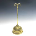 A Regency brass and cast iron door porter, with scrolled top and fluted half round base, height