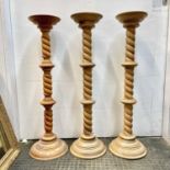 A matched trio of large wood turned and carved candle holders the columns in three barley twist