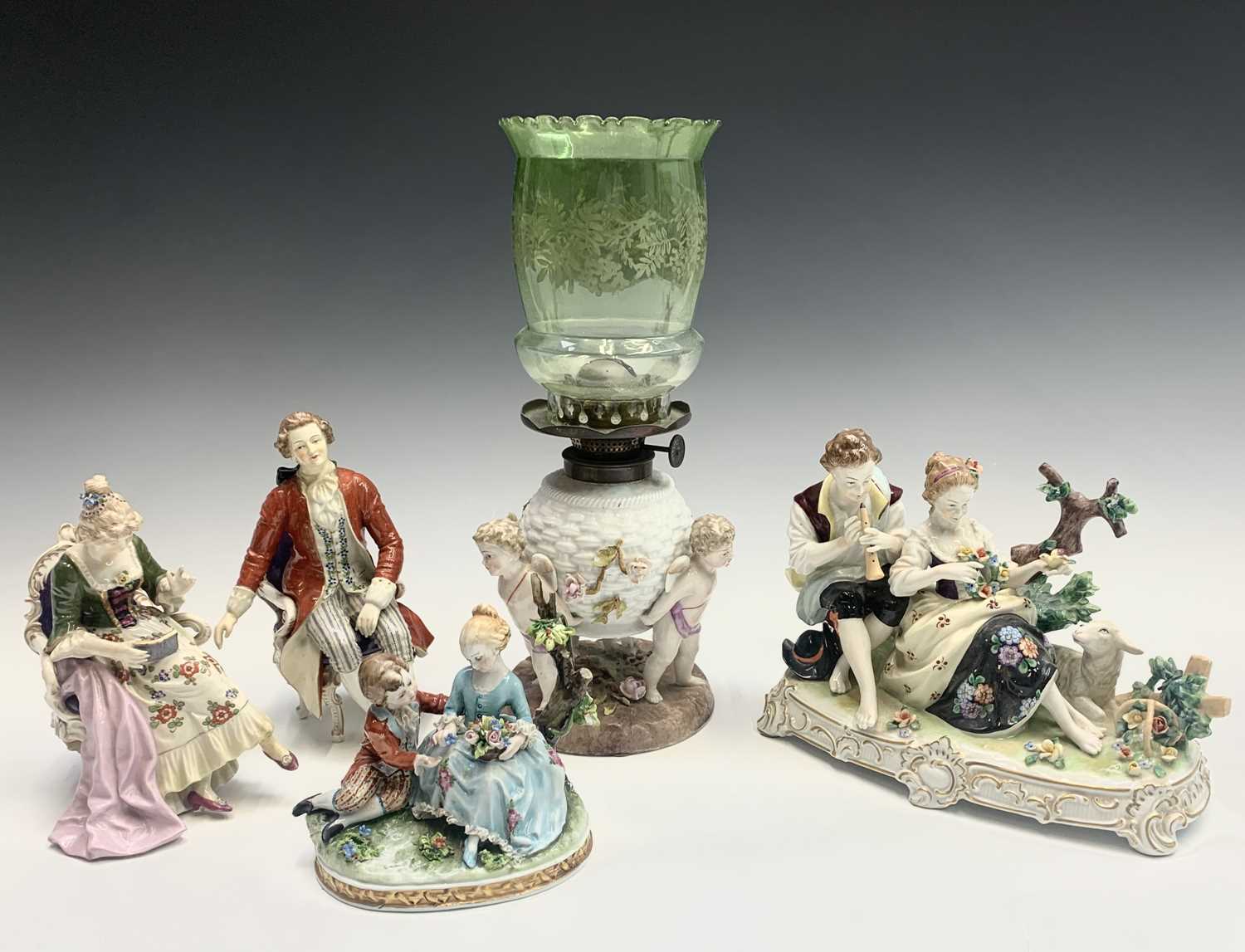 A German porcelain oil lamp base, circa 1900, modelled as a basket supported by three cherubs,