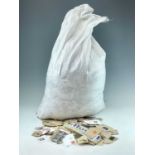 GB and World Kiloware. Large sack containing 14 kgs of mainly G.B kiloware as received from