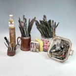 The studio collection of paint brushes, paints etc.