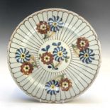 An 18th century floral decorated polychrome tin glazed plate, see paper label verso 'This plate