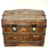 A Victorian leather covered domed top trunk, with metal bound wooden slats and leather carrying