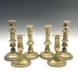 Three pairs of Georgian brass candlesticks, heights 21.5cm, 19cm and 15cm.