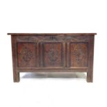 A carved oak coffer, 17th/18th century, the triple panelled hinged top and carved front, on stile