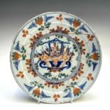 A Delft polychrome plate, 18th century, decorated with a central basket of flowers, diameter 23.
