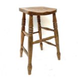 A 19th century elm and ash high stool with ring turned legs and front stretcher, height 64cm.