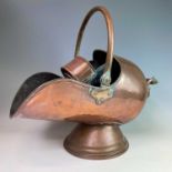 A Victorian copper coal helmet with associated scoop, width 49cm.