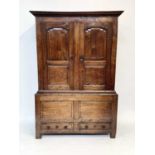 A George III oak press cupboard, with a pair of panelled doors, the lower part with two drawers,