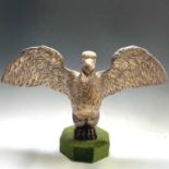 An early 18th Century carved giltwood model of an eagle, perched with outspread wings, on a velvet