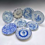 Seven Delft blue and white plates and a lobed dish, 18th century, largest diameter 22.8cm. (8)
