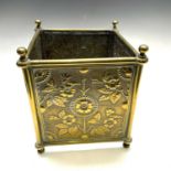 A late Victorian small square embossed brass planter, with twin handles, decorated in the