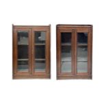 A pair of glazed oak bookcases, early 20th century, each with a raised top on a plinth base,