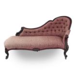 A Victorian mahogany chaise longue, the moulded and shaped back with floral and foliate carved