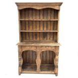A continental provincial pine dresser with two shelves above two short drawers and a pot board base,