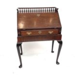 A George III style mahogany bureau on stand, 19th century, with galleried top and fitted interior on