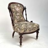 A Victorian walnut nursing chair, with turned and carved frame and upholstered back and seat, on