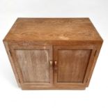 A Heal's type limed oak two door cupboard on castor wheels, signed and dated in pencil to interior R