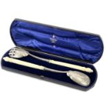 A cased pair of Victorian silver serving spoons with ivory carved handles by Harry Atkin,